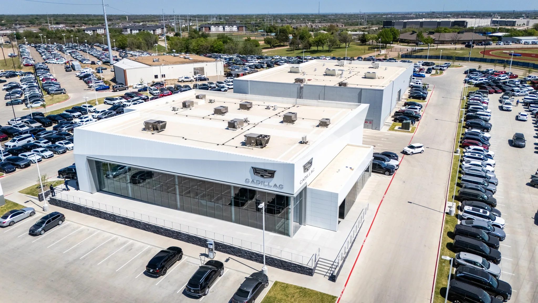 Aerial view of the Clay Cooley Cadillac dealership in Mesquite, Texas, with its white showroom and inventory lots, built by The Charles Morgan Group