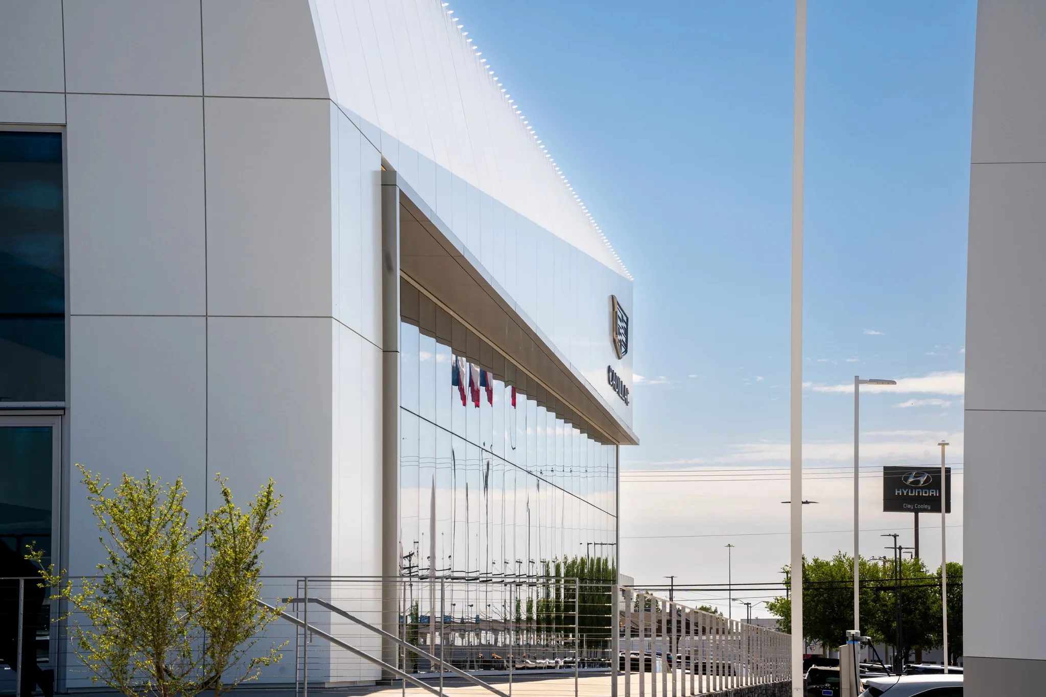 Facade detail at Clay Cooley Cadillac in Mesquite, Texas, with white metal panels, entry canopy and Cadillac crest, built by The Charles Morgan Group