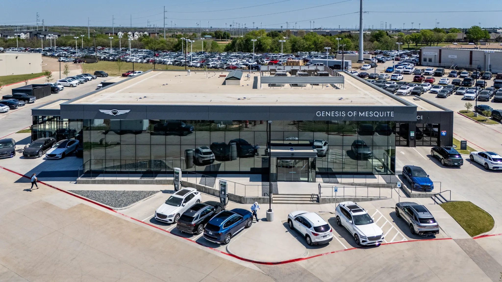 Aerial front view of the dark glass showroom at Clay Cooley Genesis of Mesquite in Mesquite, Texas, built by The Charles Morgan Group