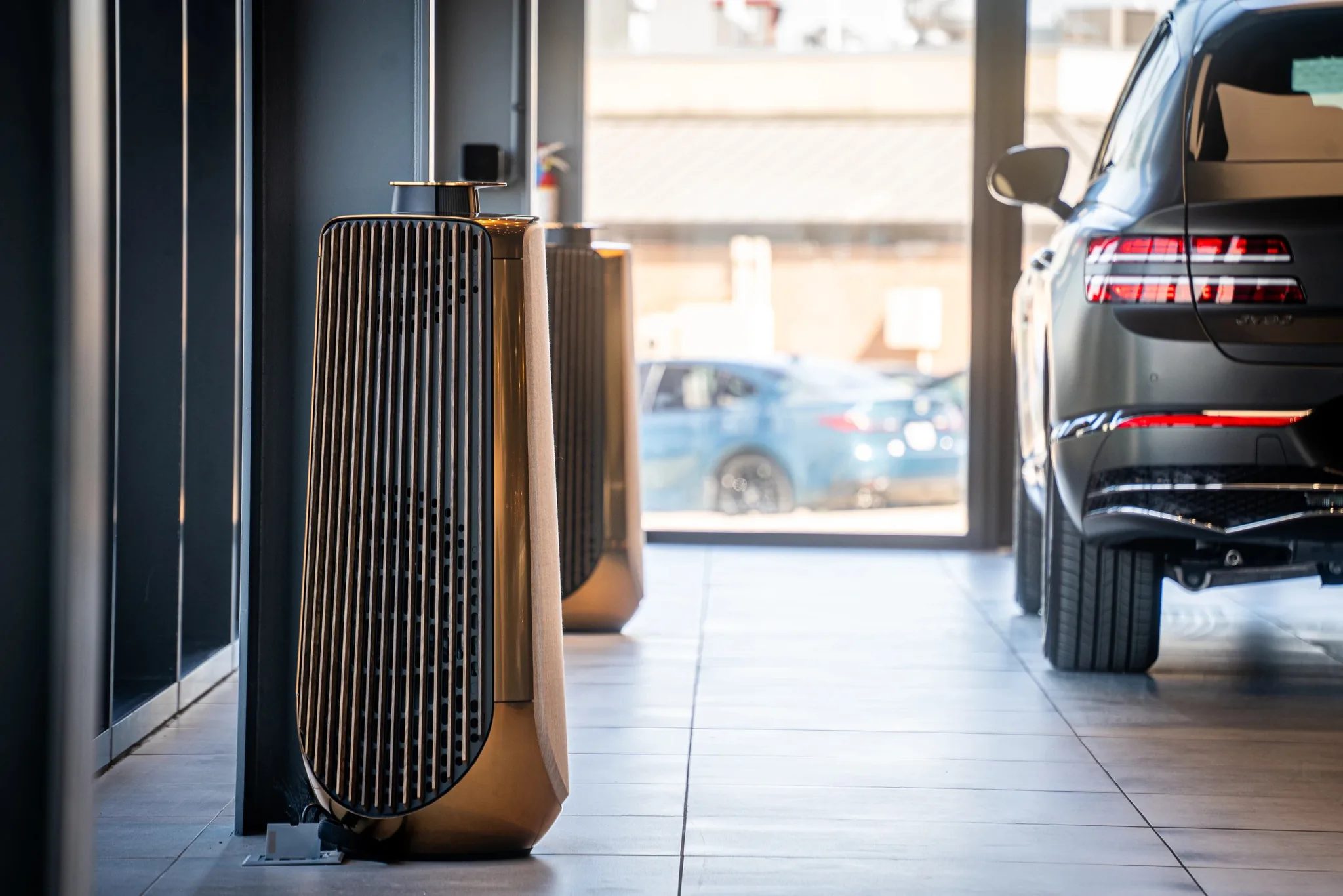 Copper-toned floor speakers and a Genesis SUV inside Clay Cooley Genesis of Mesquite in Mesquite, Texas, built by The Charles Morgan Group