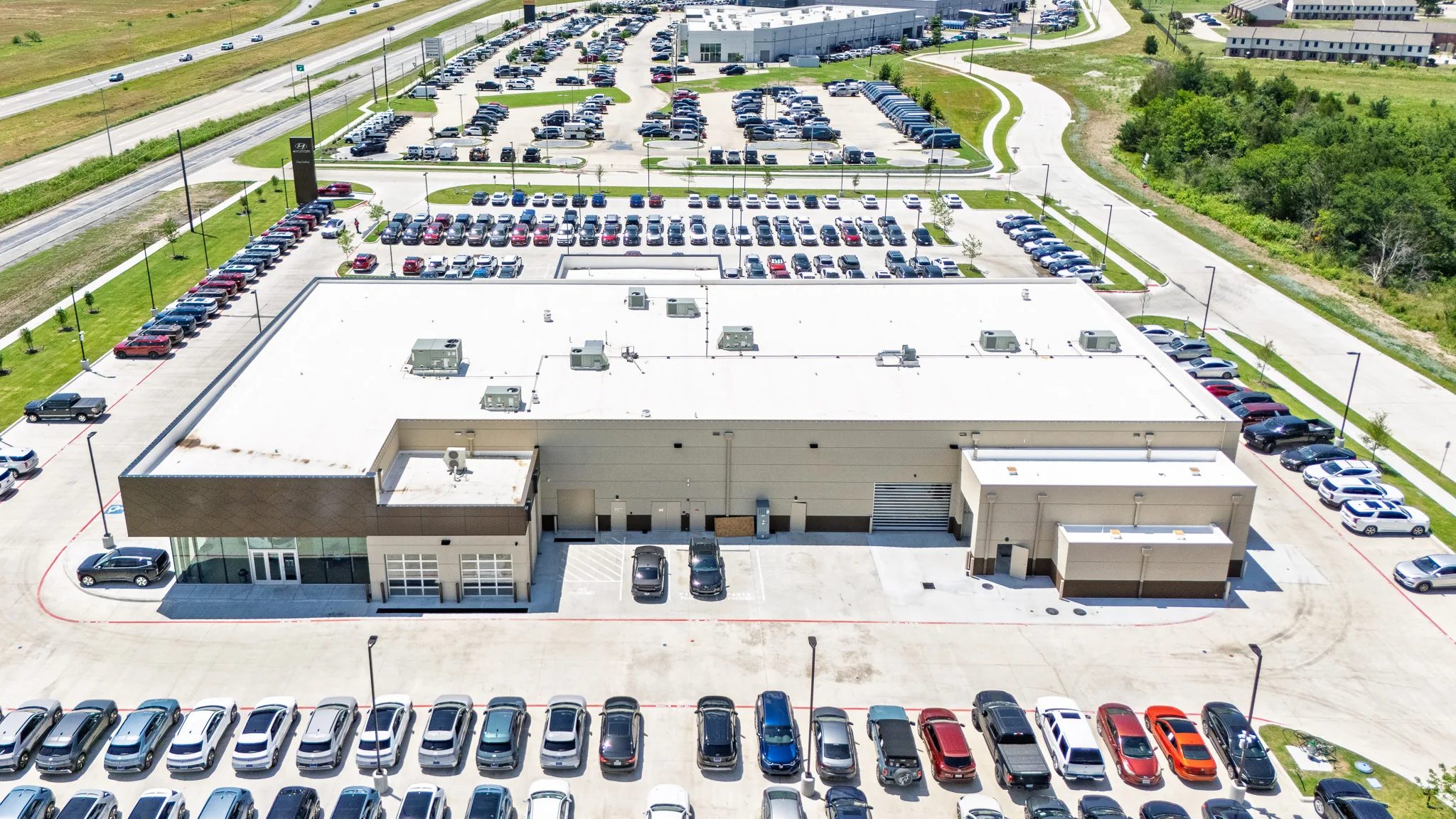 Rear aerial view of Clay Cooley Hyundai of Terrell in Terrell, Texas, with service bays and inventory lots, built by The Charles Morgan Group