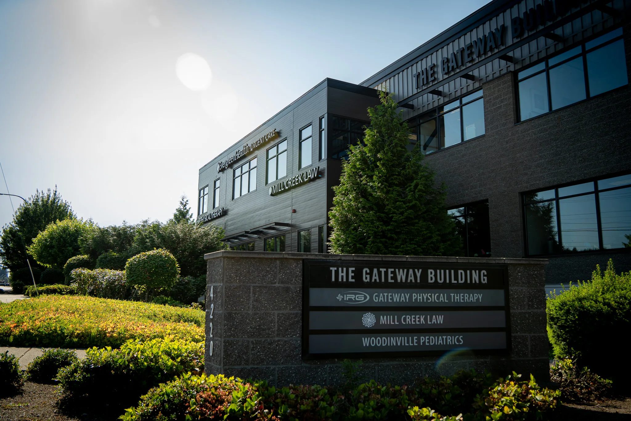 Monument sign for The Gateway Building listing IRG Gateway Physical Therapy, with the two-story building rising behind it.