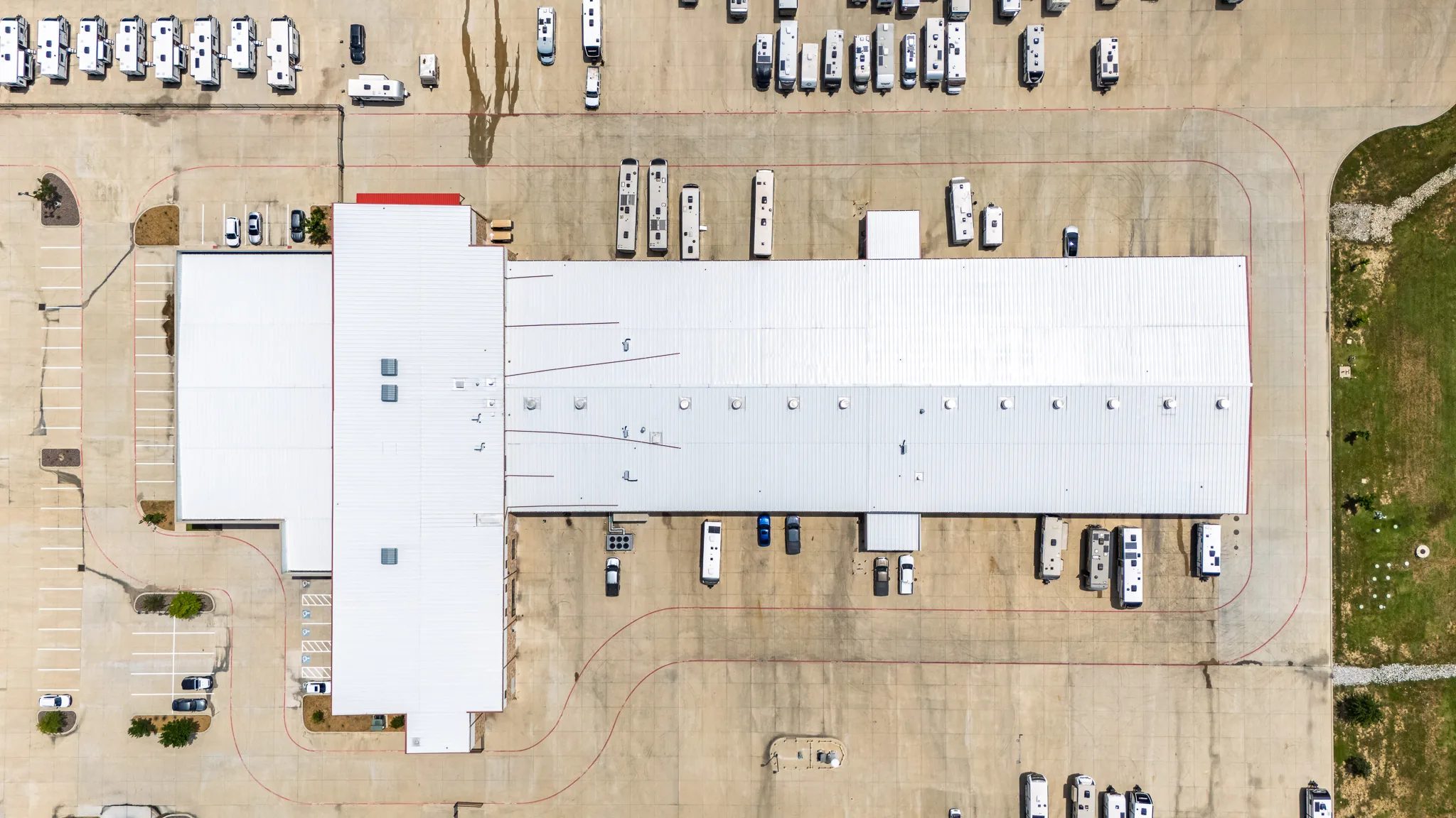 Top-down aerial of the McClain's RV SuperStore service building in Sanger, Texas, ringed by parked RVs, built by The Charles Morgan Group
