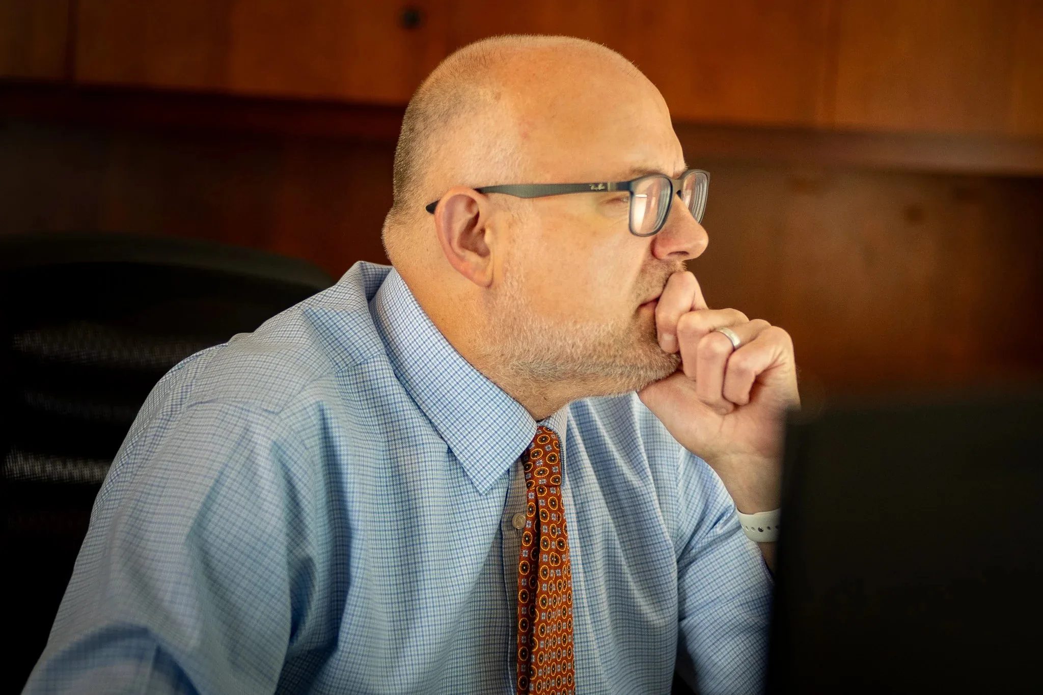 Kevin P. Ahearn, Attorney at Nelson Law Firm, chin resting on one hand, studies a computer screen.