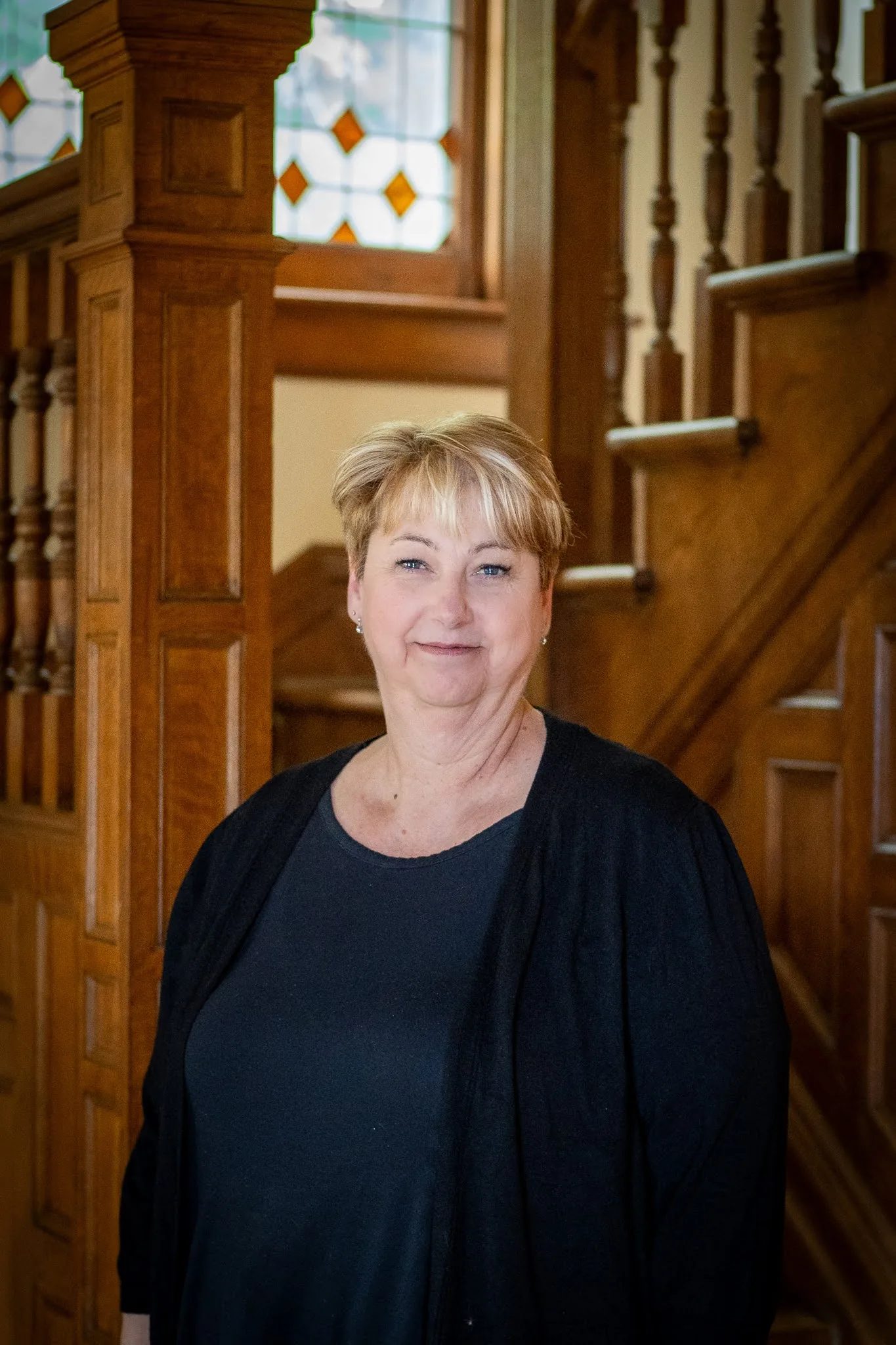 Dawn Schulte, office manager at Nelson Law Firm, at the oak staircase of the firm's historic Denver office