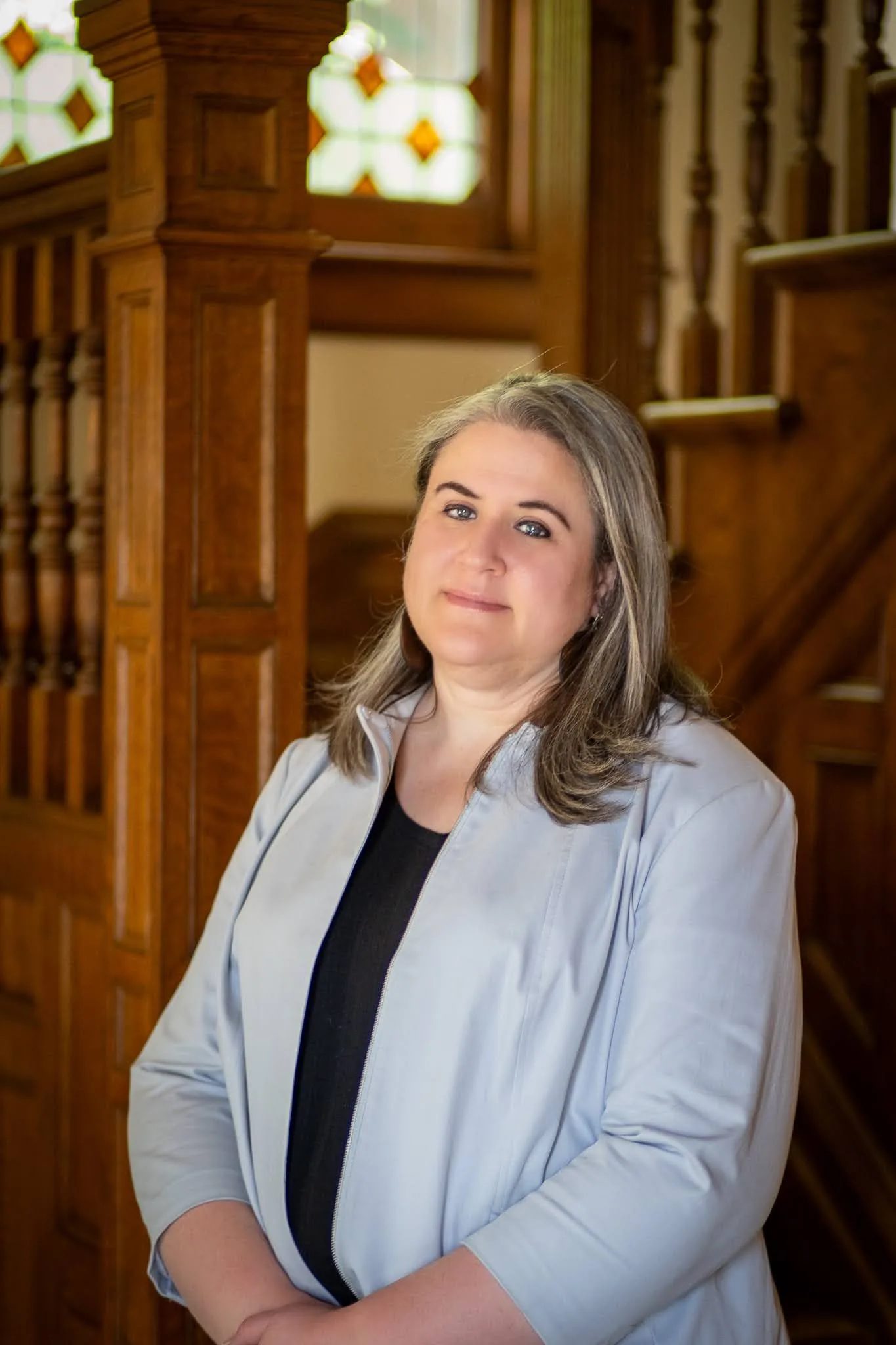 Marcia Forney, paralegal at Nelson Law Firm, at the stained-glass staircase of the firm's historic Denver office
