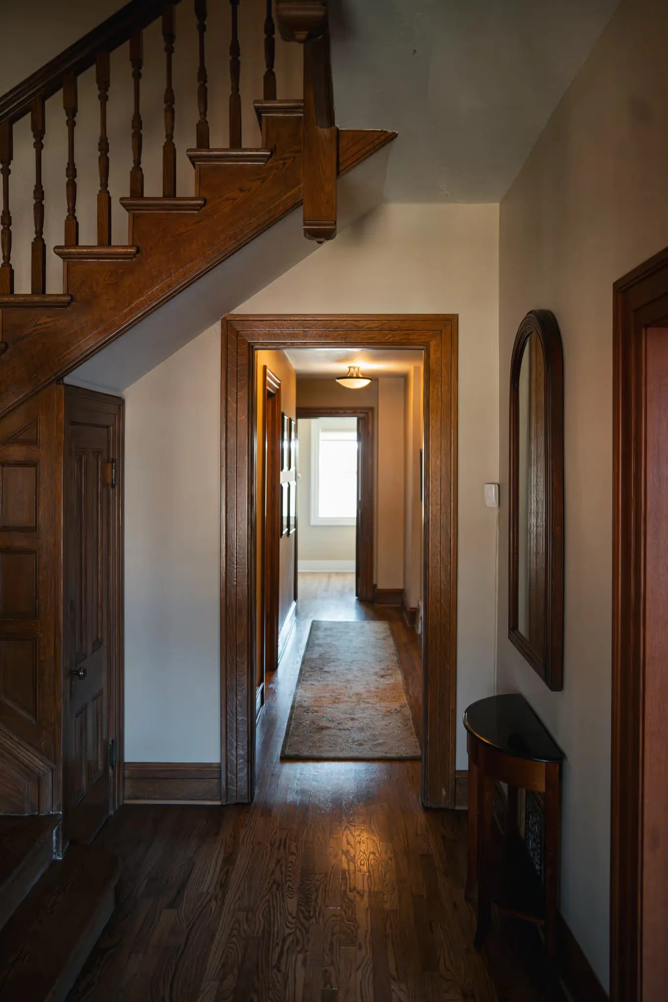Oak staircase and a wood-trimmed hallway with a runner rug inside Nelson Law Firm's historic Denver office.
