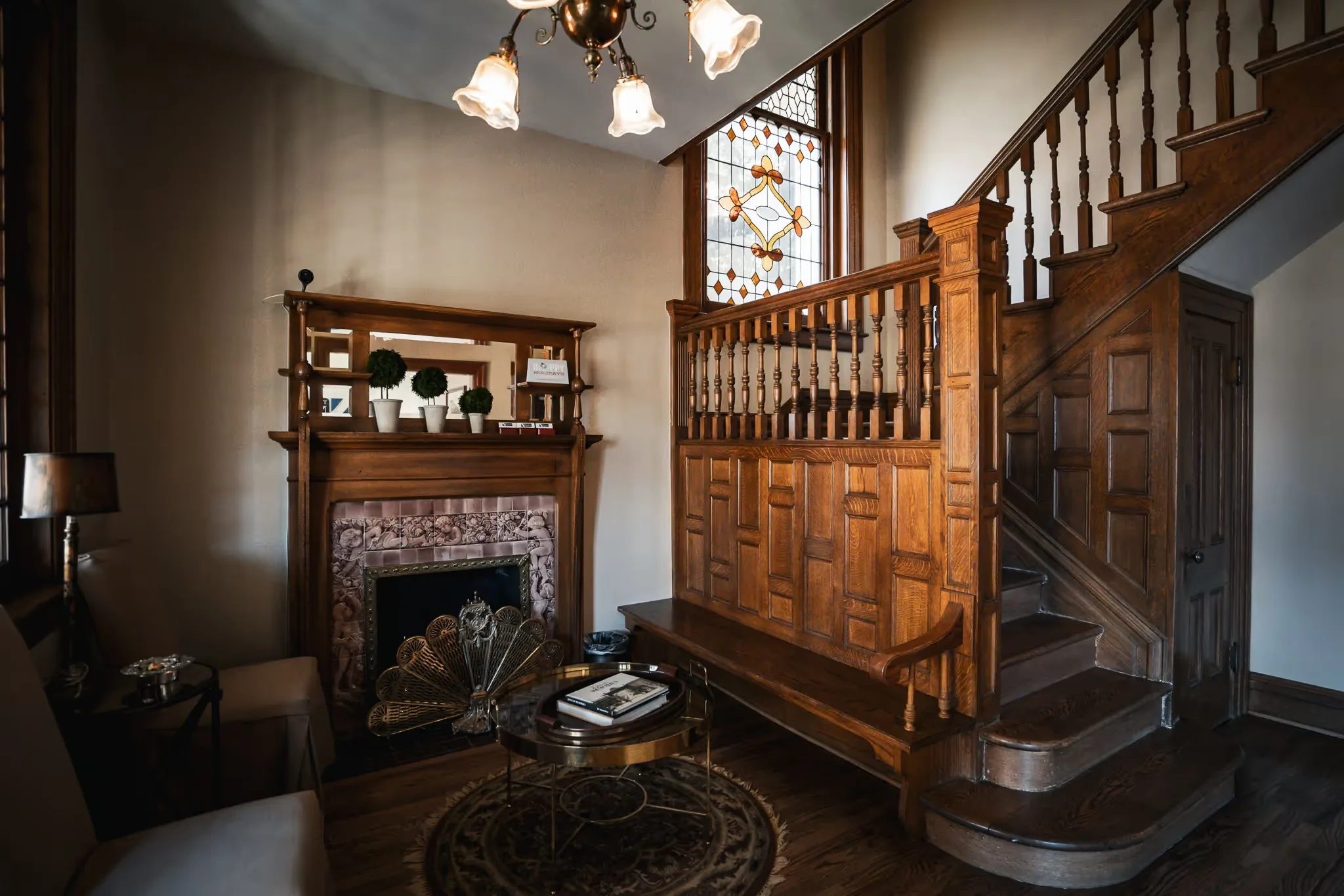 Antique fireplace, oak staircase with paneled newel post and stained glass in the parlor of Nelson Law Firm's Denver office.
