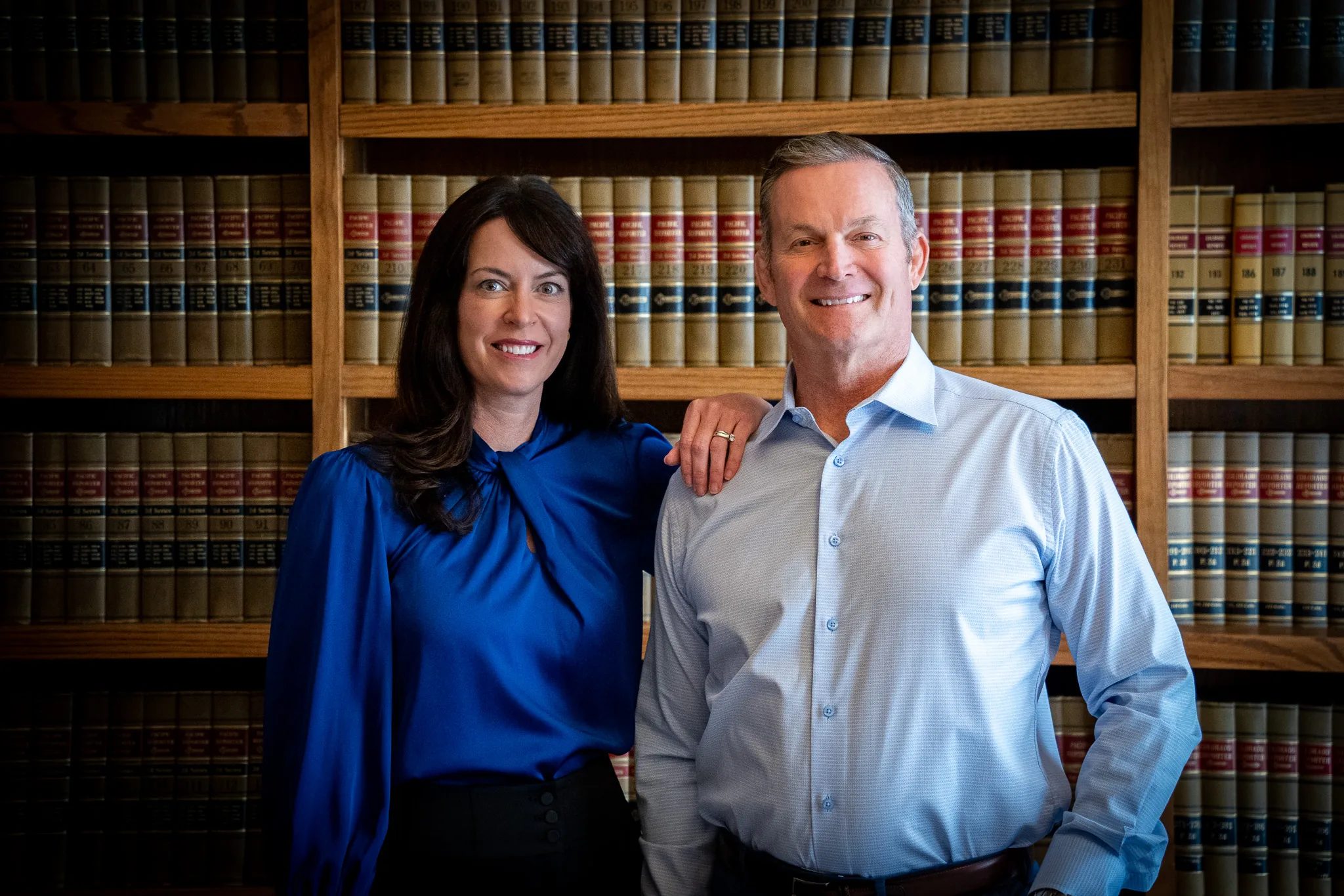 Mark W. Nelson and Colleen S. Nelson, founders of Nelson Law Firm, standing together in the firm's law library in Denver