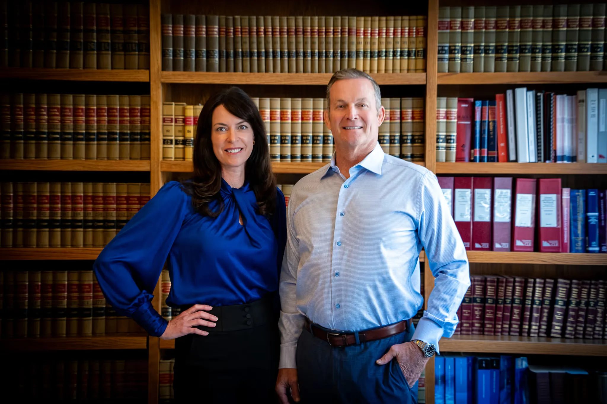 Mark W. Nelson and Colleen S. Nelson, founders of Nelson Law Firm, smiling together in the firm's law library in Denver