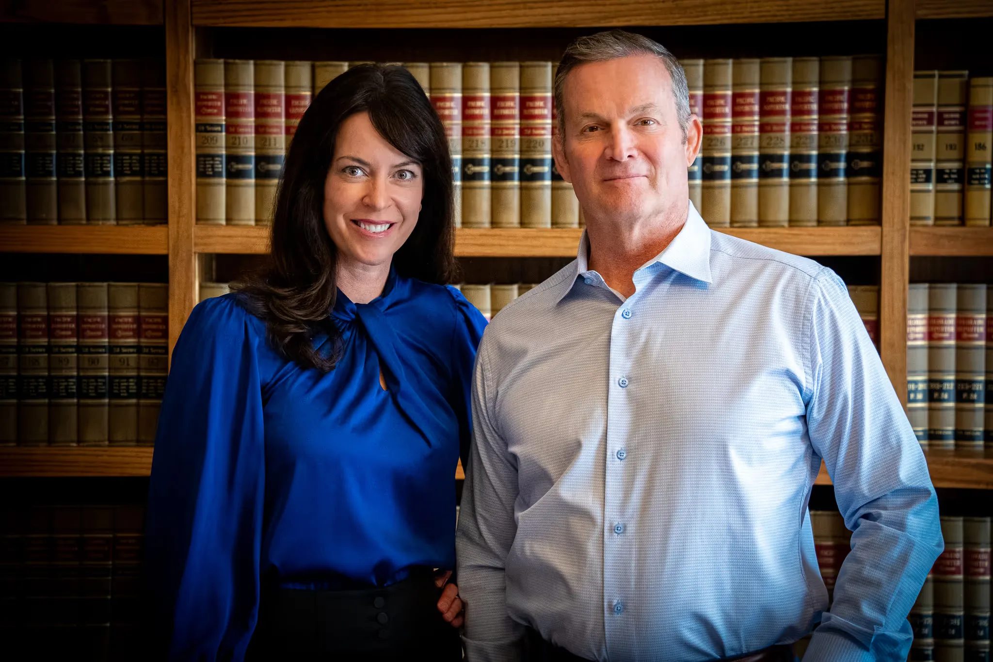 Colleen S. Nelson and Mark W. Nelson, founders of Nelson Law Firm, standing close together in the firm's Denver law library