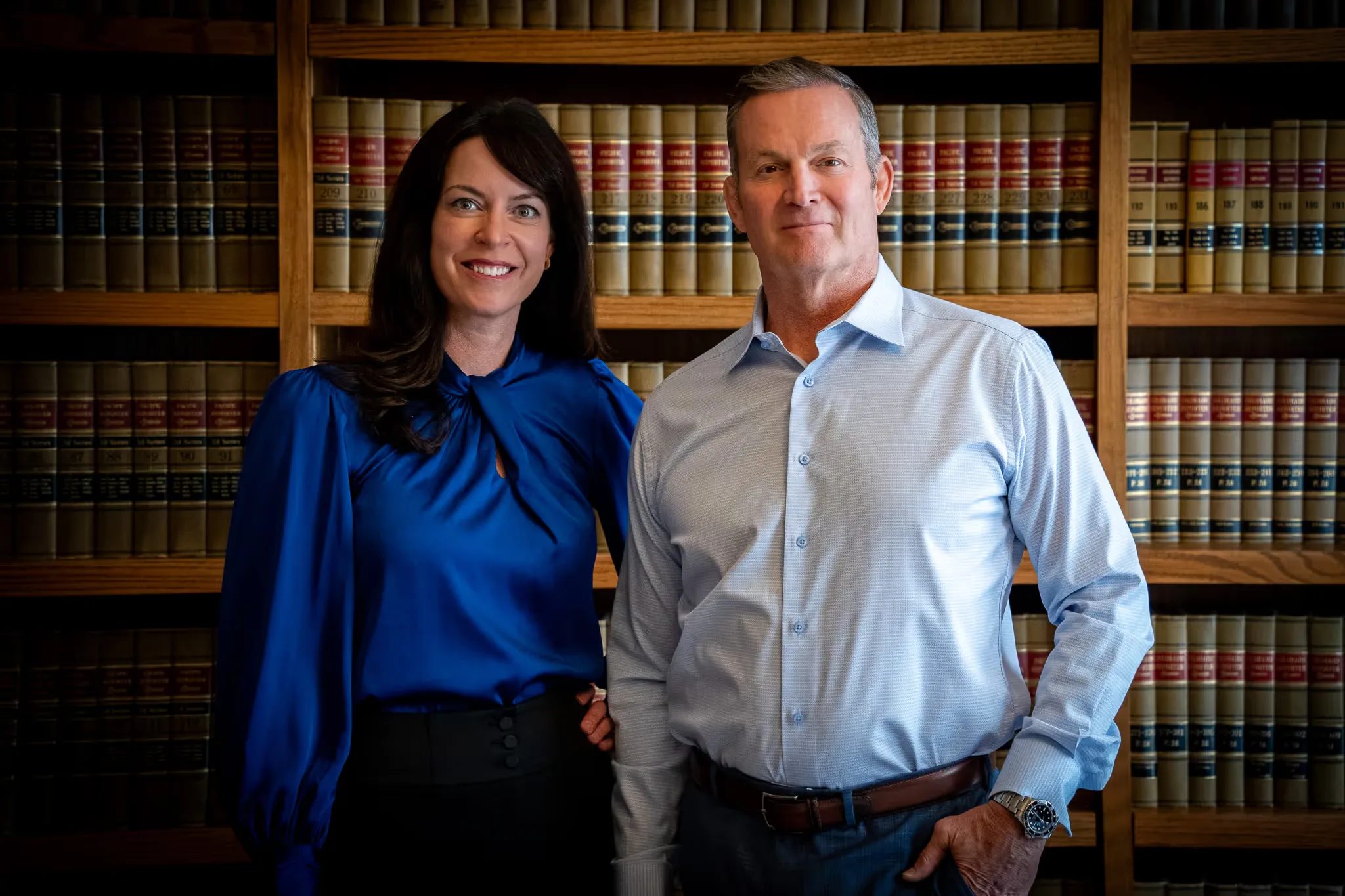 Mark W. Nelson and Colleen S. Nelson, founders of Nelson Law Firm, smiling in the firm's law library in Denver
