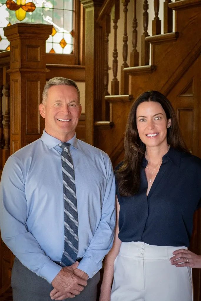 Mark W. Nelson and Colleen S. Nelson, founders of Nelson Law Firm, side by side at the staircase of the firm's Denver office