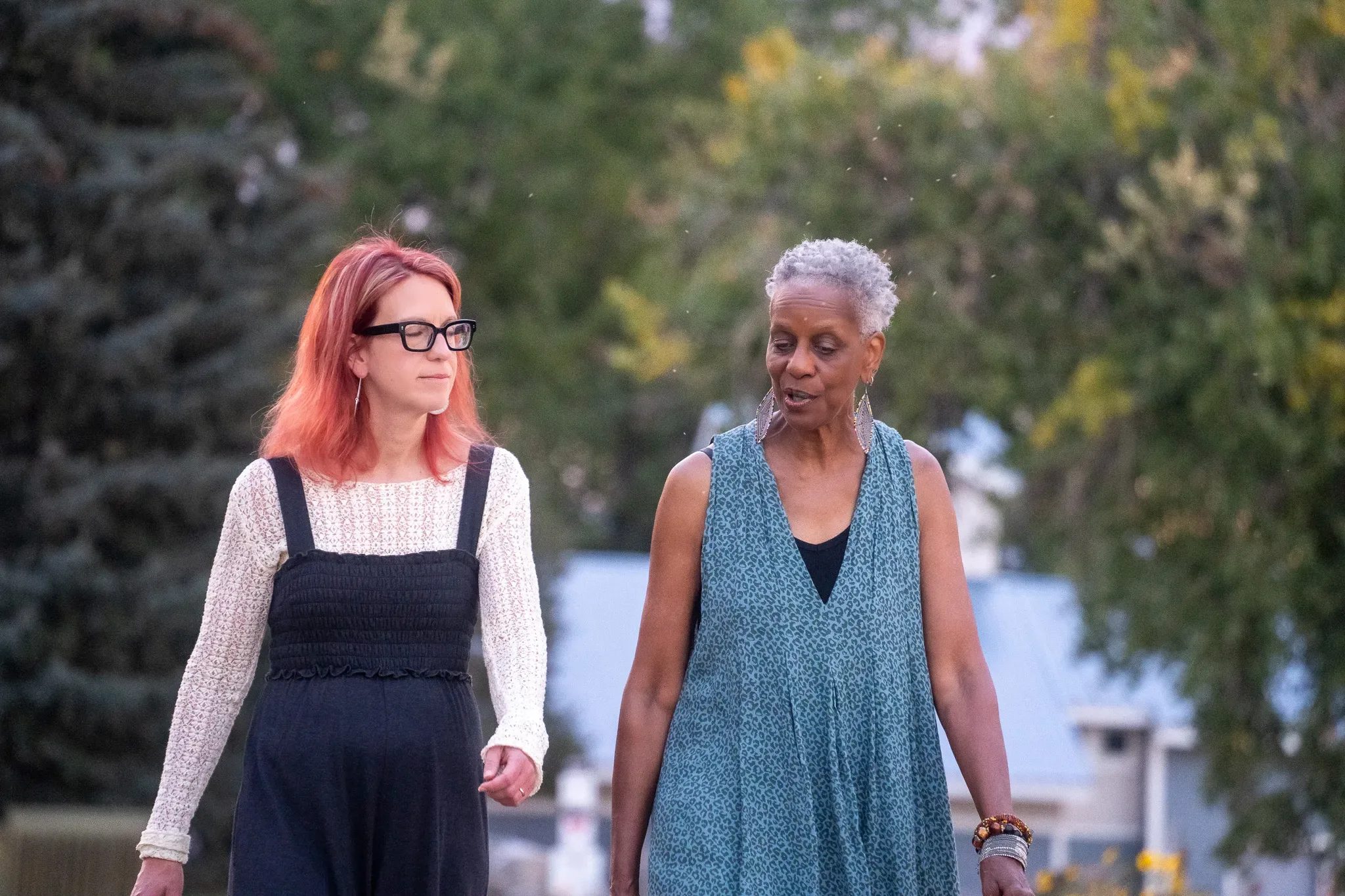 The two Who Tells the Story founders walking and talking together outdoors
