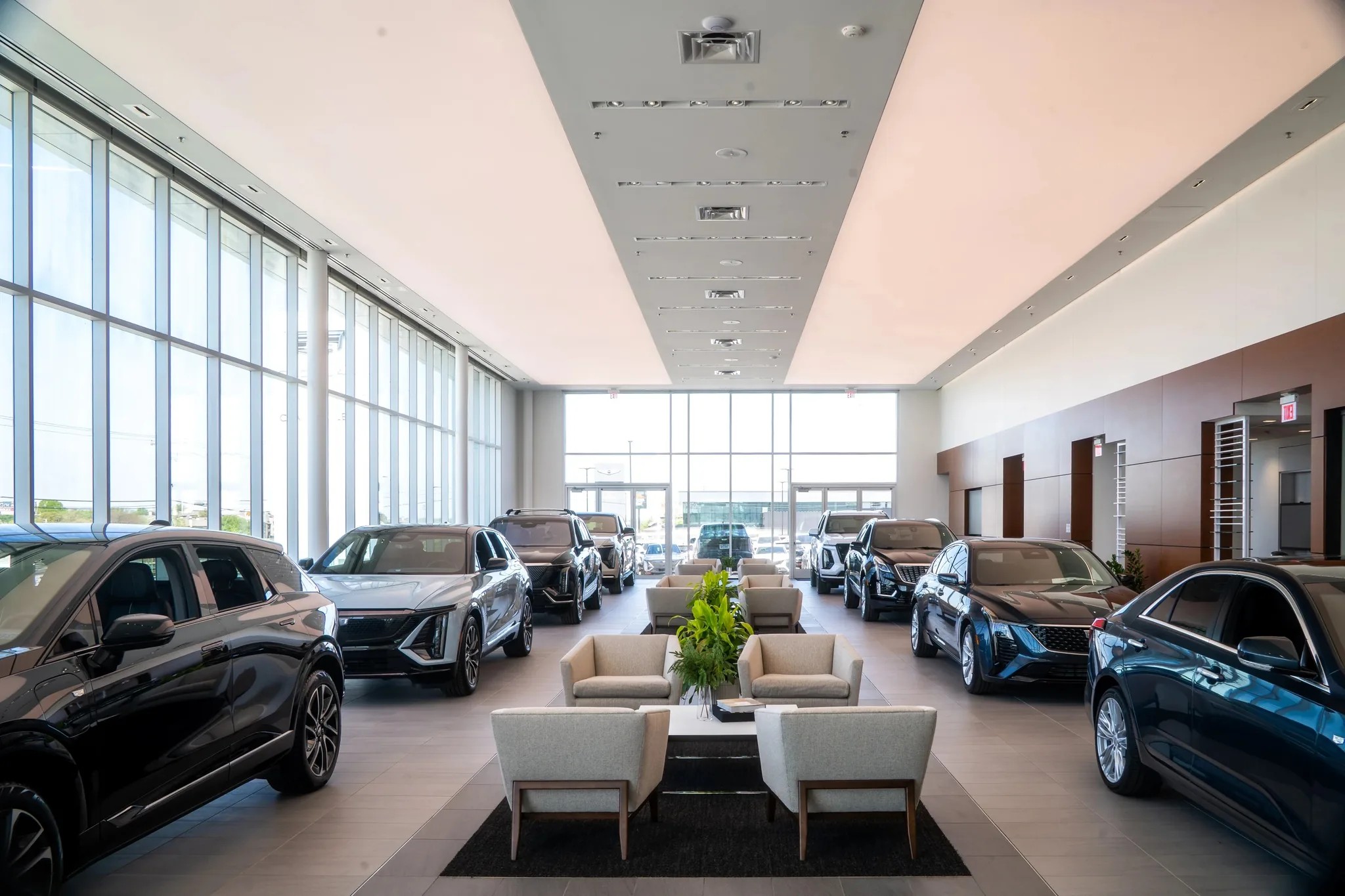 Showroom interior at Clay Cooley Cadillac in Mesquite, Texas, with new Cadillacs flanking a lounge seating area, built by The Charles Morgan Group