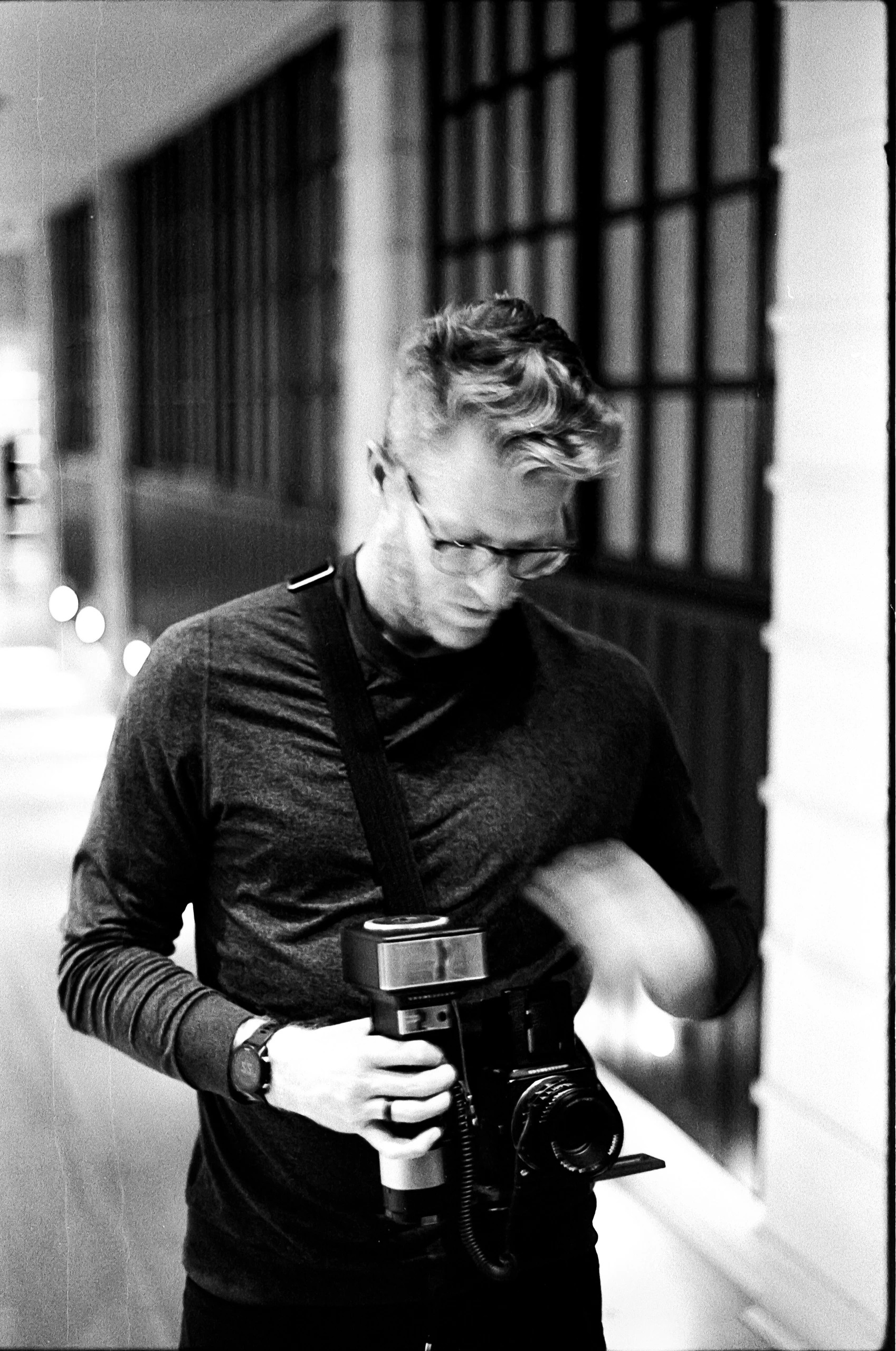 Cody Strate, founder of UPWARD, holding a camera in black and white.